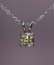 A fancy yellow diamond pendant, the round brilliant-cut stone weighing approx. 0.51 carat, claw-