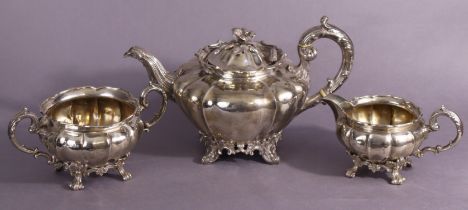 A matched three-piece silver tea service of melon shape, comprising a Victorian teapot with flower-