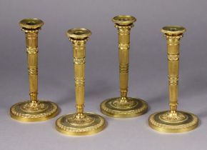 A set of four late 19th/early 20th century gilt-brass candlesticks, in the neoclassical style,