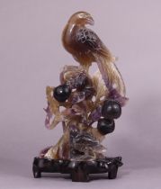 A late 19th/early 20th century Chinese carved amethyst-quartz model of a phoenix, perched atop