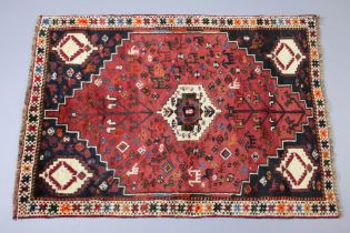 A Persian Qashqai rug of madder ground with floral & animal motifs surrounded by geometric