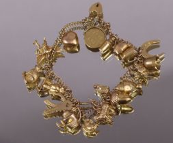 A 9ct gold curb-link bracelet with twenty-two pendant charms, & padlock clasp with safety china. (