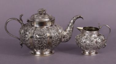 An Indian white metal teapot of round lobed form, with all-over repoussé decoration of animals &