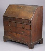 A 19th century oak bureau with a fitted interior enclosed by a fall-front above a mock-drawer &