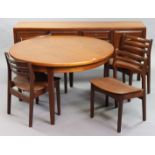 A 1970’s teak circular extending dining table with an additional leaf, & on four square tapered