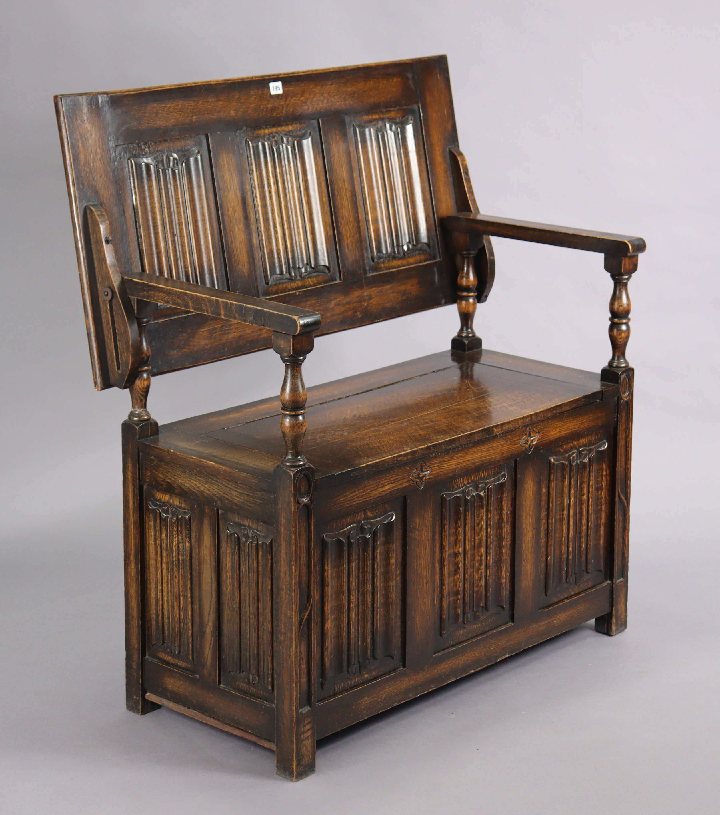 A reproduction oak monk’s bench with fold-over top, hinged box-seat, & carved linen-fold panels to - Image 3 of 4