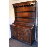 A good quality reproduction oak dresser in the 18th century style, fitted three shelves and six