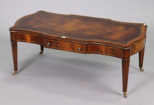 A reproduction mahogany rectangular low coffee table inset gilt-tooled brown leather, fitted with