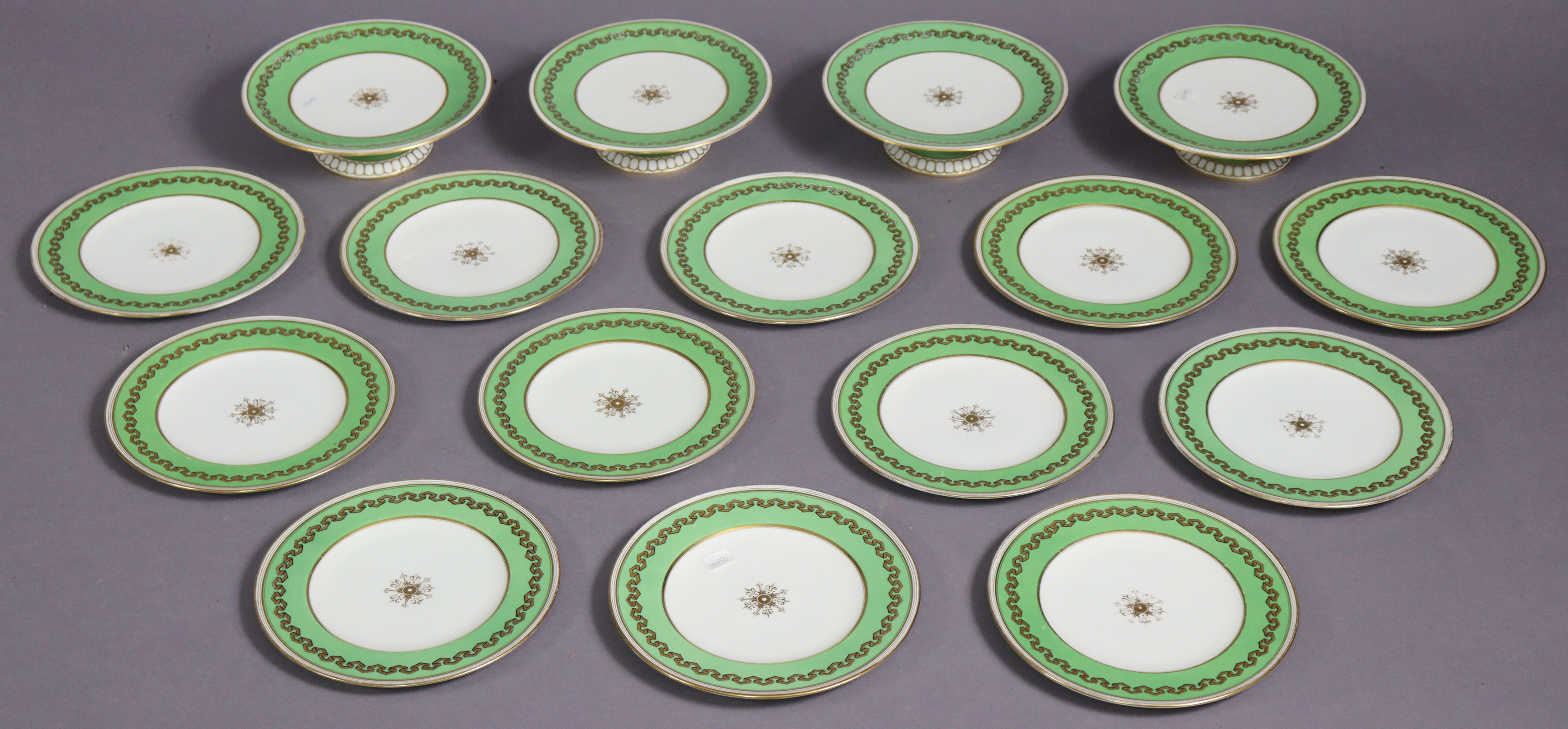 An early 20th century English porcelain part dessert service with apple-green borders & gilt