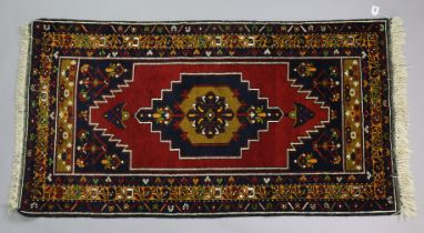 A Turkoman rug of deep blue ground with central medallion in multiple floral borders, 177cm x 90cm.