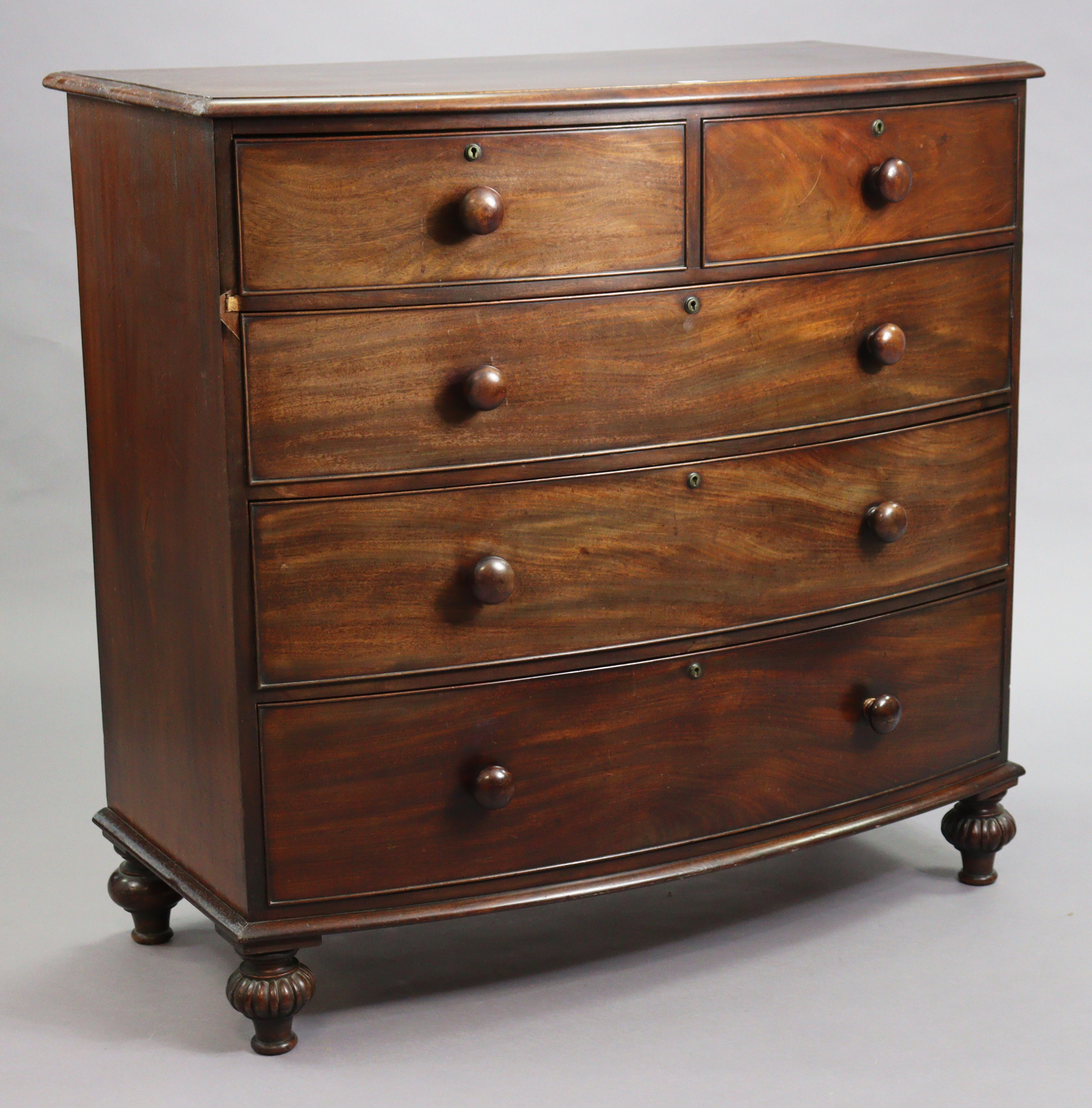 A 19th century mahogany bow-front chest fitted two short & three long graduated drawers with