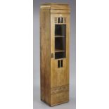 An oak tall standing narrow cabinet having four adjustable shelves enclosed by a bevelled glass &