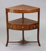 A late 18th century mahogany bow-front two-tier corner stand fitted with a centre drawer to the