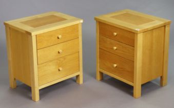 A pair of light oak three-drawer bedside chests, 53cm wide x 60.5cm high.