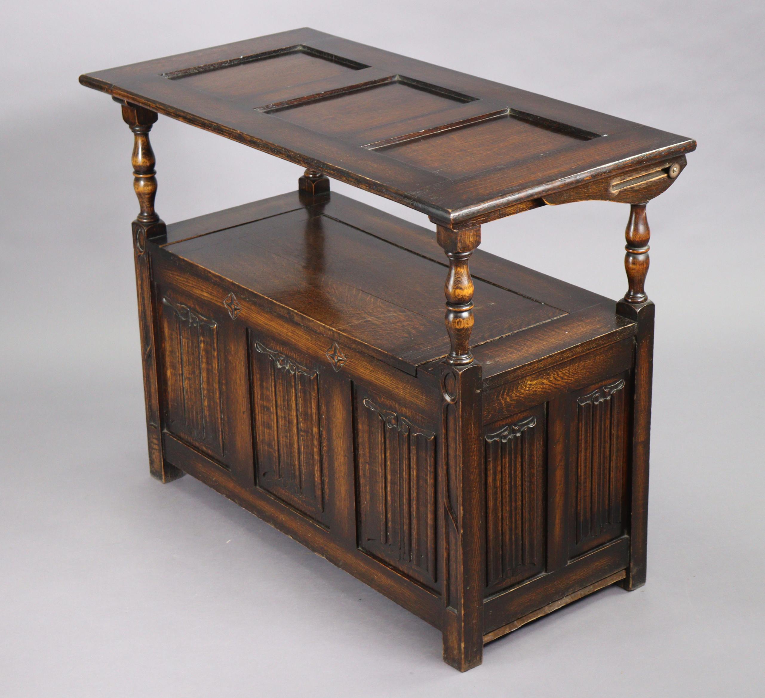 A reproduction oak monk’s bench with fold-over top, hinged box-seat, & carved linen-fold panels to - Image 4 of 4