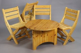 A set of four pine fold-away kitchen chairs; & a pine fold-away table with a circular top.