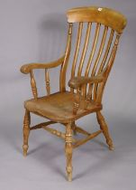 A Late 19th/early 20th century lath-back elbow chair with a hard seat, & on turned legs with