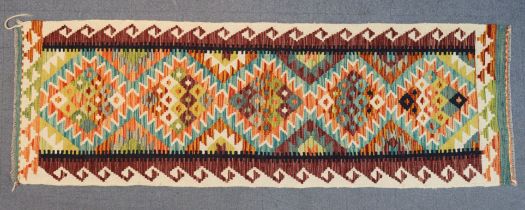 A Chobi kilim runner with all-over multicoloured geometric designs, 190cm x 64cm.