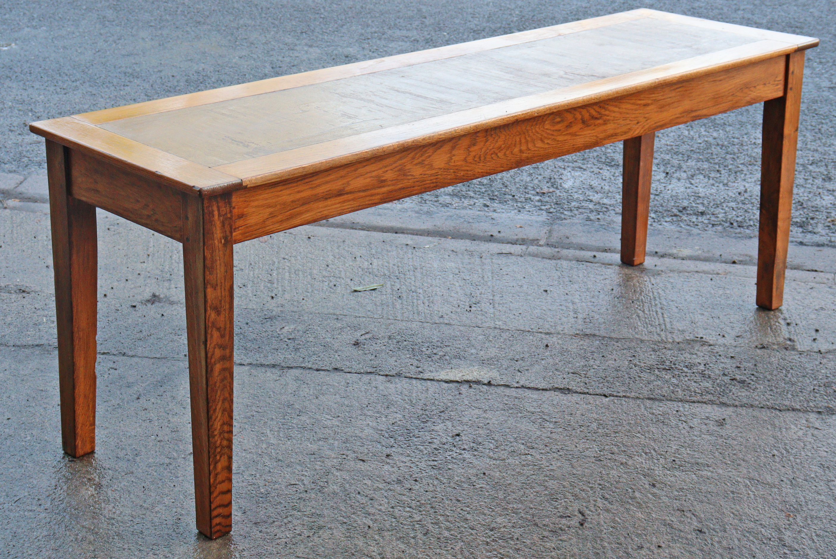 An oak office writing table inset brown leather to the narrow rectangular top, & on four square