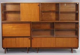 A mid-20th century teak tall wall unit fitted with an arrangement of shelves & cupboards, & on short