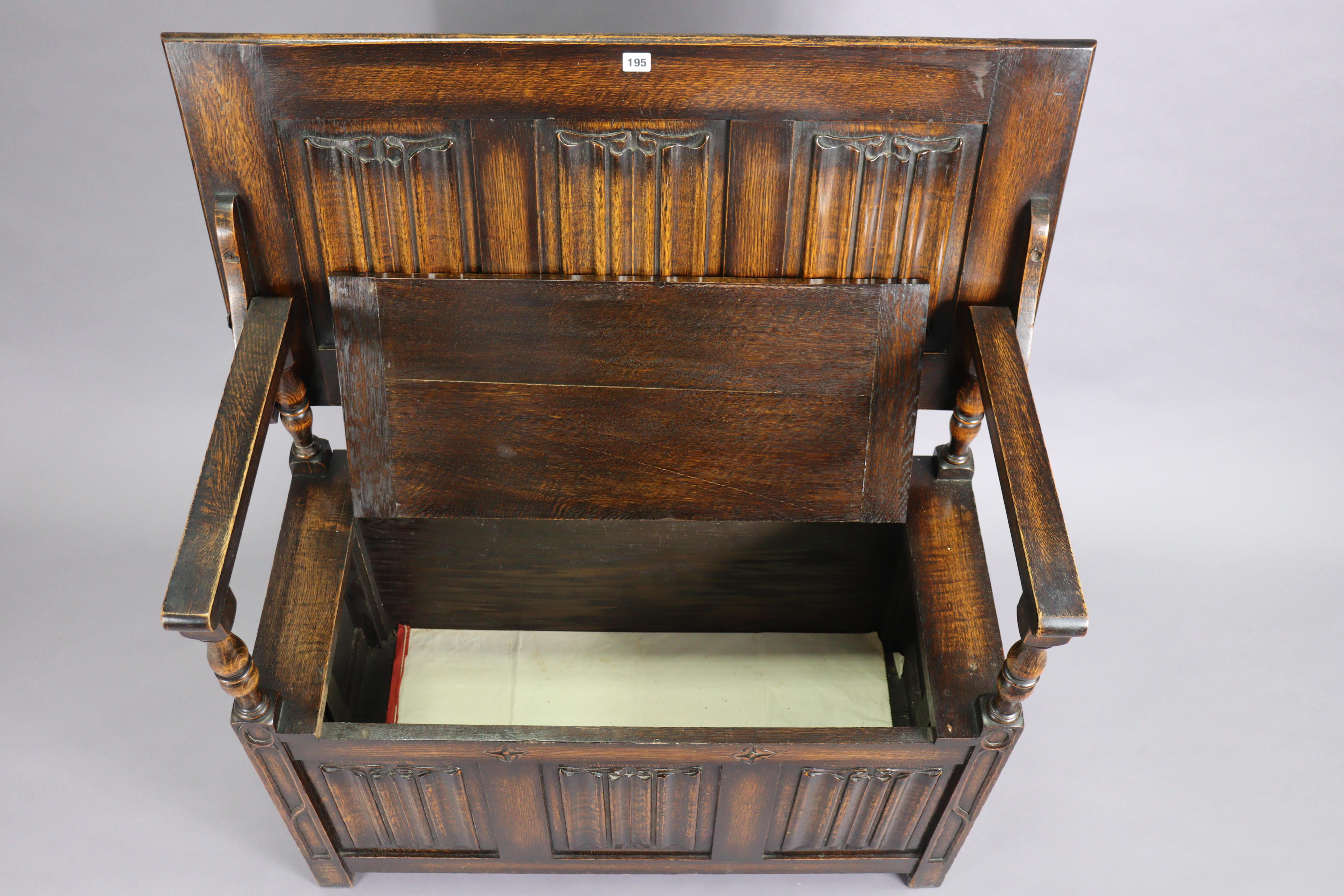 A reproduction oak monk’s bench with fold-over top, hinged box-seat, & carved linen-fold panels to - Image 2 of 4