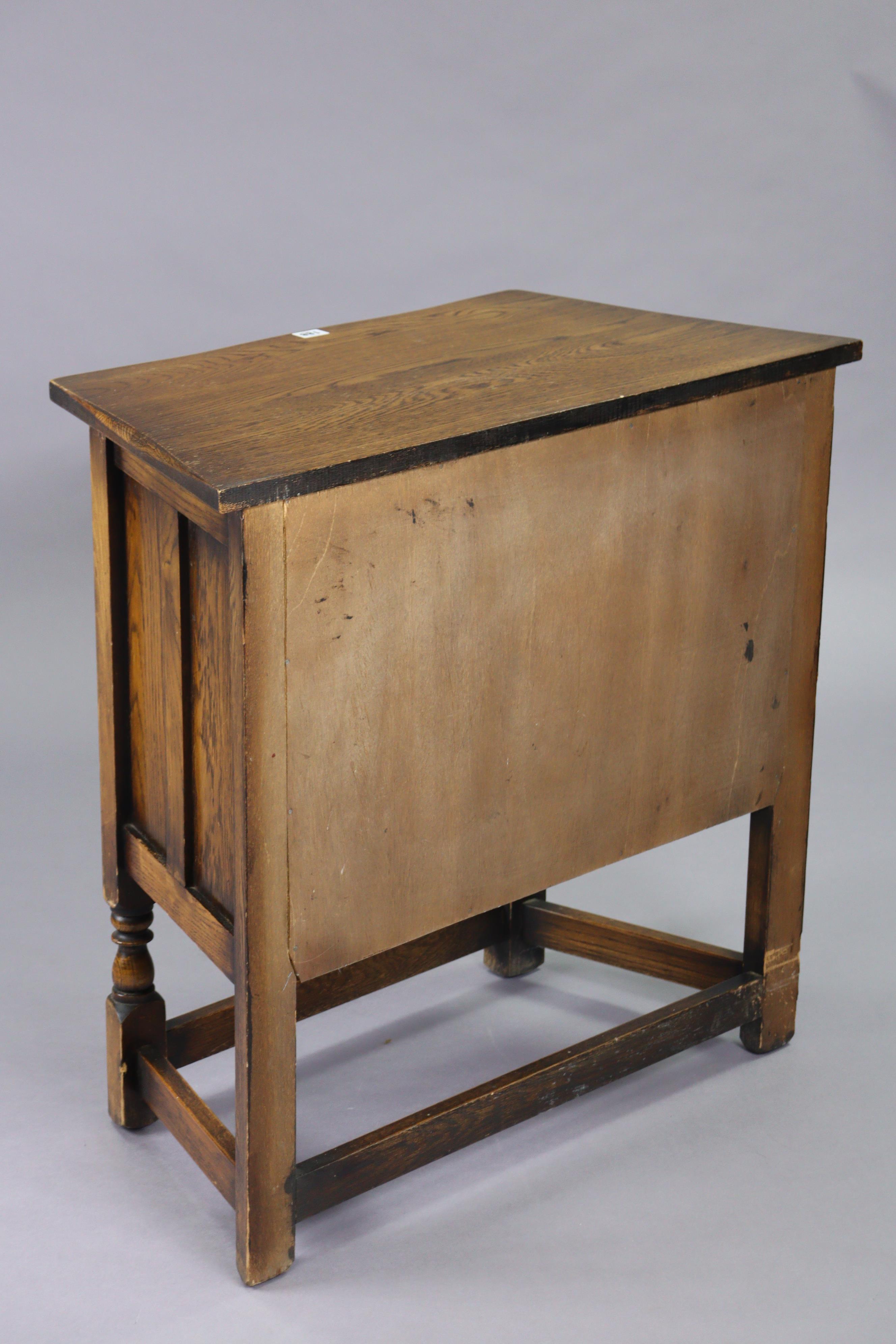 A small oak side cabinet with canted sides, enclosed by a carved panel door, & on turned supports - Image 3 of 3