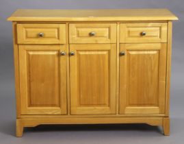 A light oak/ash sideboard fitted three frieze drawers above cupboards enclosed by three fielded pa