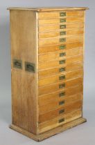 An early 20th century tall oak standing cutlery cabinet fitted fifteen long graduated drawers with