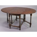 A 1930’s oak oval gate-leg dining table on barley-twist legs & turned feet with plain stretchers,