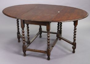 A 1930’s oak oval gate-leg dining table on barley-twist legs & turned feet with plain stretchers,