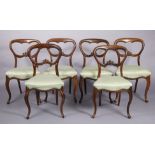 A set of six mid-Victorian rosewood dining chairs with carved rounded open backs, padded seats, & on