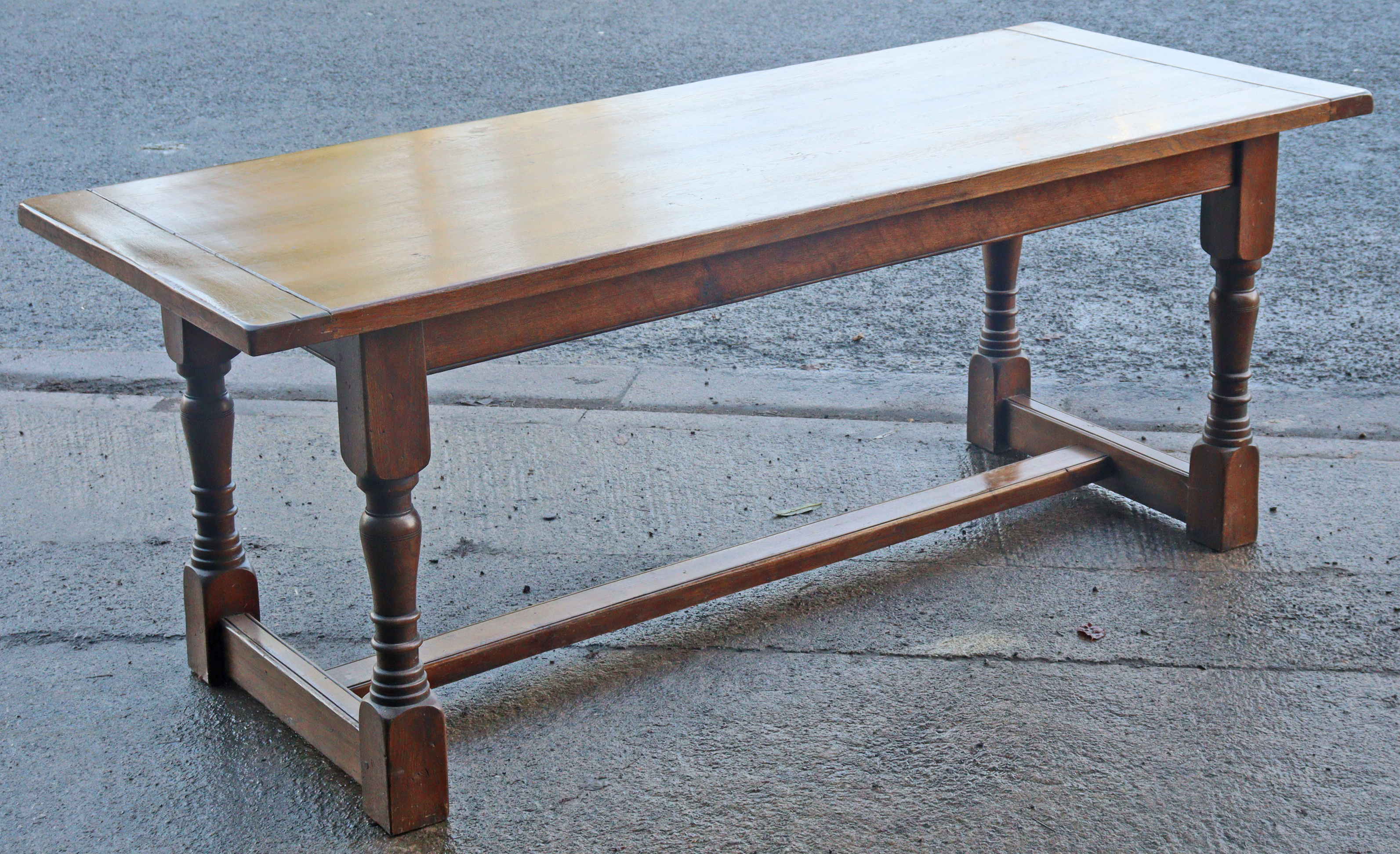 An oak refectory table with a rectangular top, & on four baluster turned legs with plain stretchers,