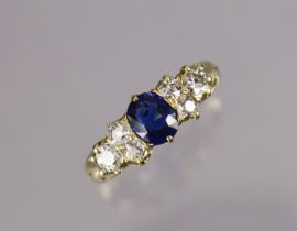An un-marked gold ring set oval-cut sapphires between trios of small diamonds, size N/O, 3.4g.