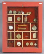 A display of clockmakers accessories, including a pocket watch case; two pocket watch dials, etc.,
