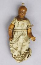 A Victorian small wax head-&-shoulders girl doll, dressed, 18cm high.