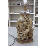 A 20thC Chinese soapstone table lamp with metal mounts, ornately carved in relief with a bird of