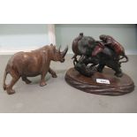 A 20thC Japanese bronze group, lionesses attacking an elephant  6"h; and a carved wooden model rhino