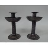 A pair of Arts & Crafts inspired steel candlesticks, each comprising a socket with a flared rim