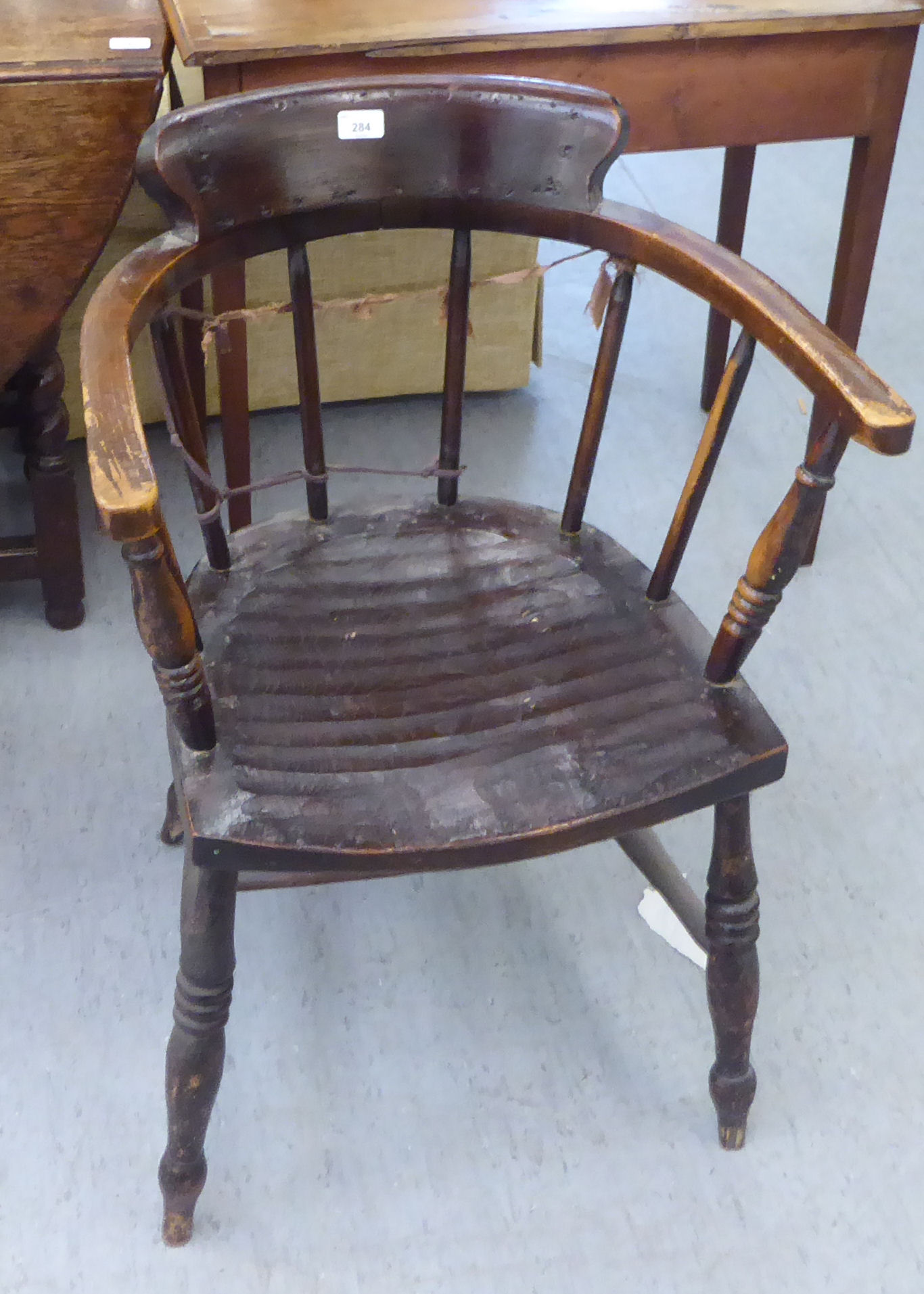 An early 20thC stained beech framed captain's chair with a spindled back and solid seat, raised on - Image 2 of 2