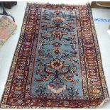 A Persian woollen rug, decorated with stylised flora and foliage, on a blue ground  77" x 48"