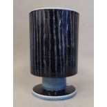 A Poole pottery vase of cylindrical, pedestal cup design, decorated in tones of blue with random