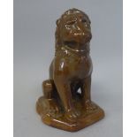 An early 20thC brown glazed pottery model, a seated lion in heraldic pose  bears incised marks  6"h