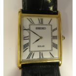 A Seiko Solar square, gold plated cased wristwatch, faced by a Roman dial, on a black hide strap