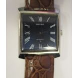 A 1960s Seiko square, stainless steel cased wristwatch, faced by a black Roman dial, on a brown hide