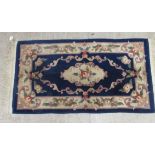 A Chinese wash woollen rug, on a blue ground  27" x 56"