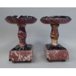 A pair of early 20thC Continental mottled iron red and green marble, sidepiece comports, on