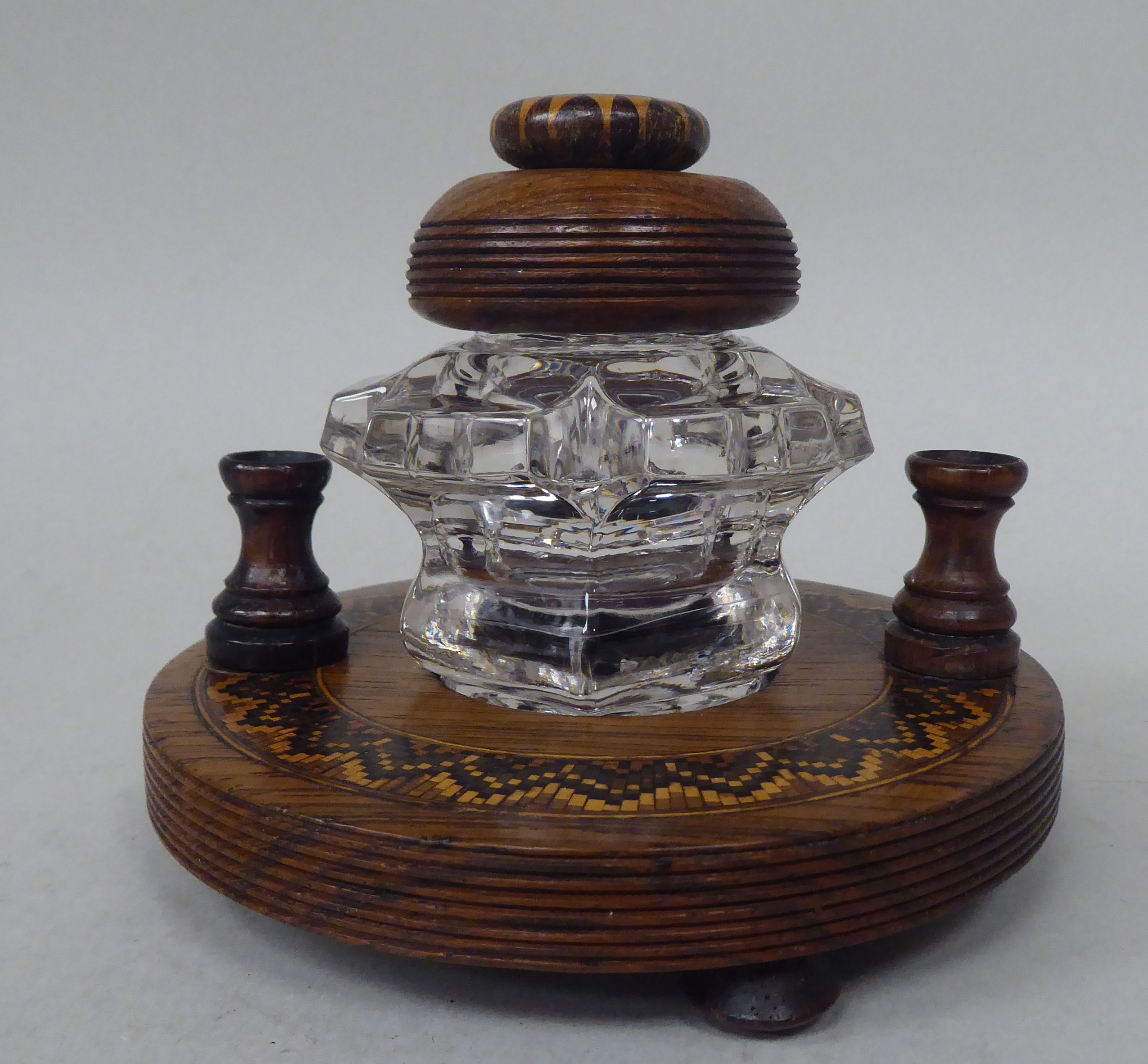 A Tonbridgeware rosewood inkstand with a moulded glass reservoir and cap, on a circular platform,