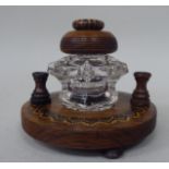 A Tonbridgeware rosewood inkstand with a moulded glass reservoir and cap, on a circular platform,