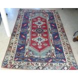 A Persian rug, decorated with repeating stylised designs, on a multi-coloured ground  60" x 100"