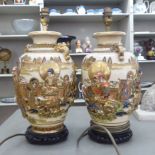 A pair of mid 20thC Japanese satsuma porcelain table lamps, each decorated with figures in relief